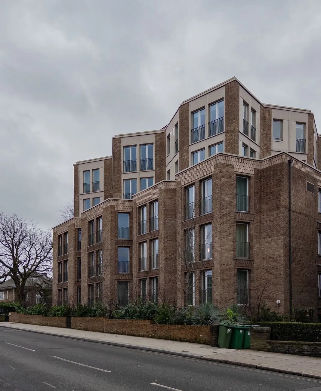 Modern brick apartment building with stepped upper floors and Juliet balconies